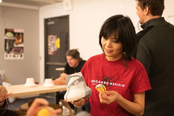 在一间艺术工作室里，一名身穿红色DigiPen Dragons t恤的女子正在装饰一件窑烧陶器.