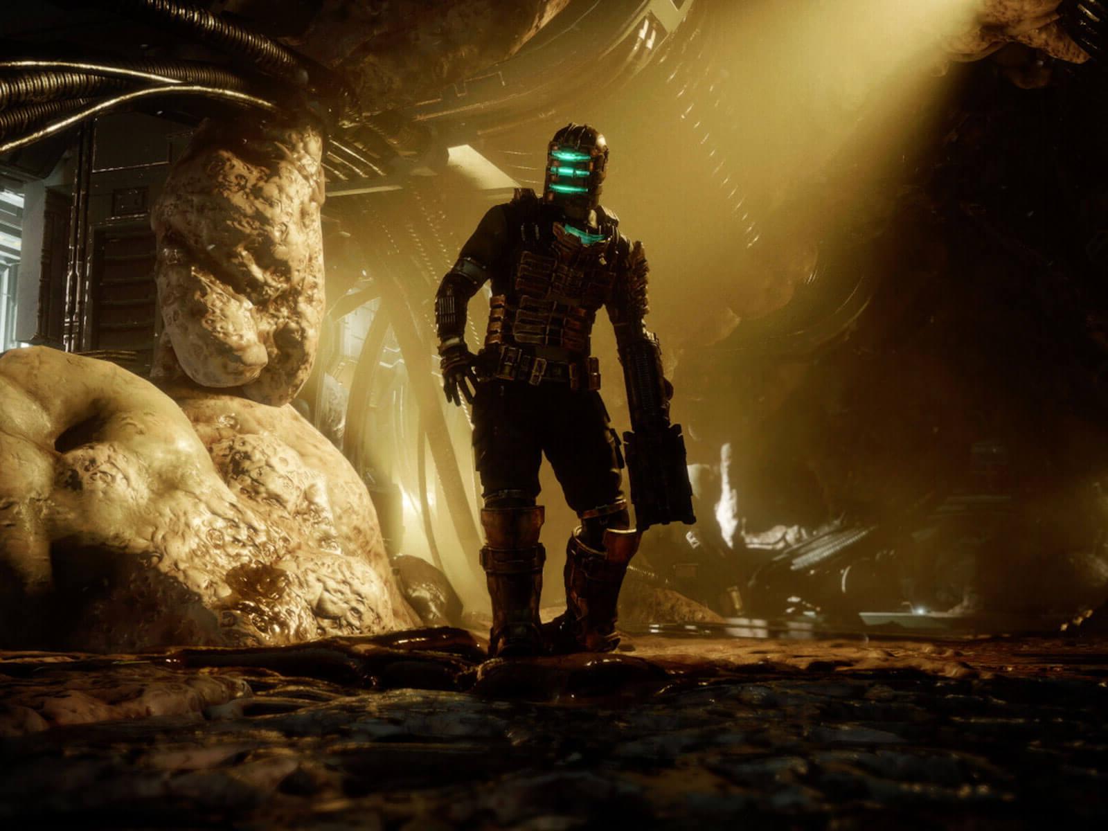 Dead Space protagonist Isaac Clarke stands in a dimly lit room with grotesque organic material growing over the floors, walls, and ceilings.